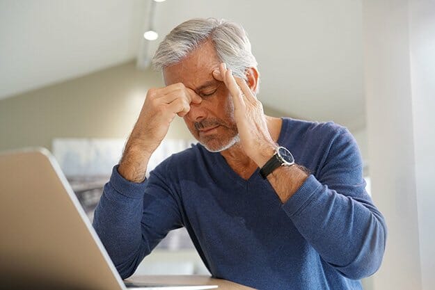 Senior man having a headache while working on laptop computer Loss of Muscle Mass ss body