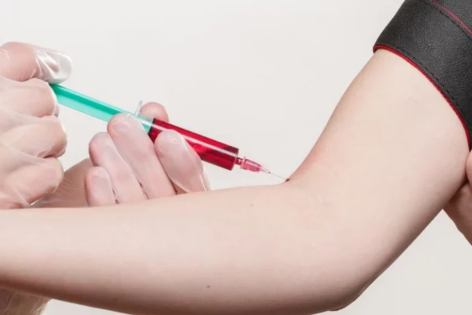 woman getting her blood drawn from a syringe