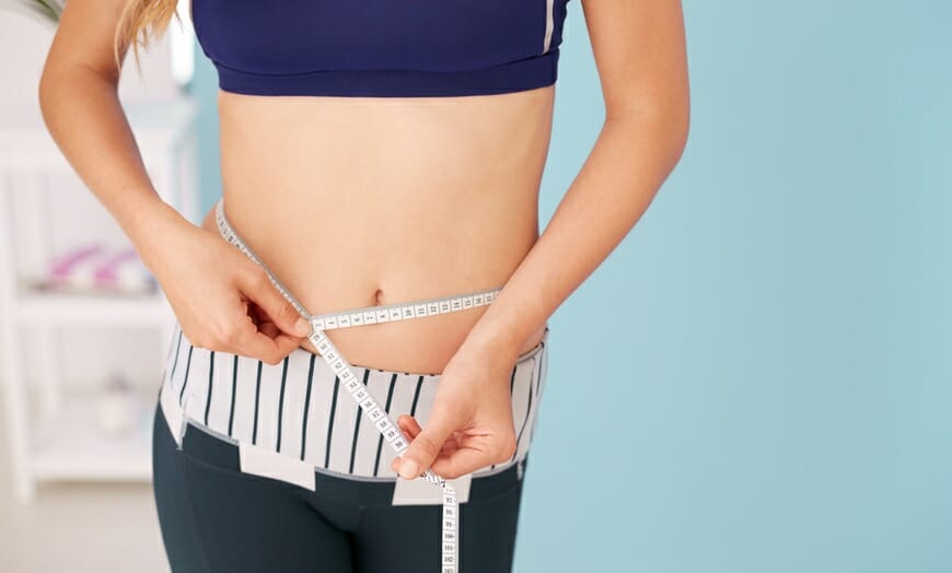 woman measuring her waist