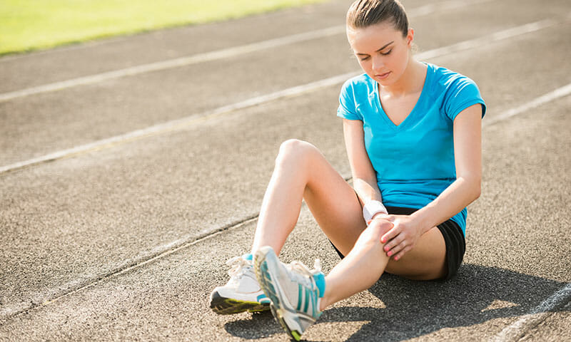 woman sitting down on a running track