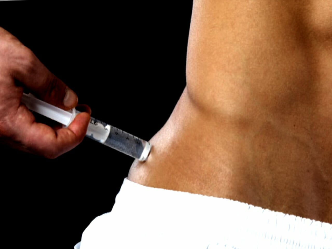 man injecting himself in the abdomen