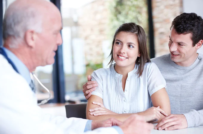 doctor talking with couple