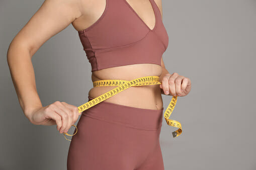 woman measuring her waist