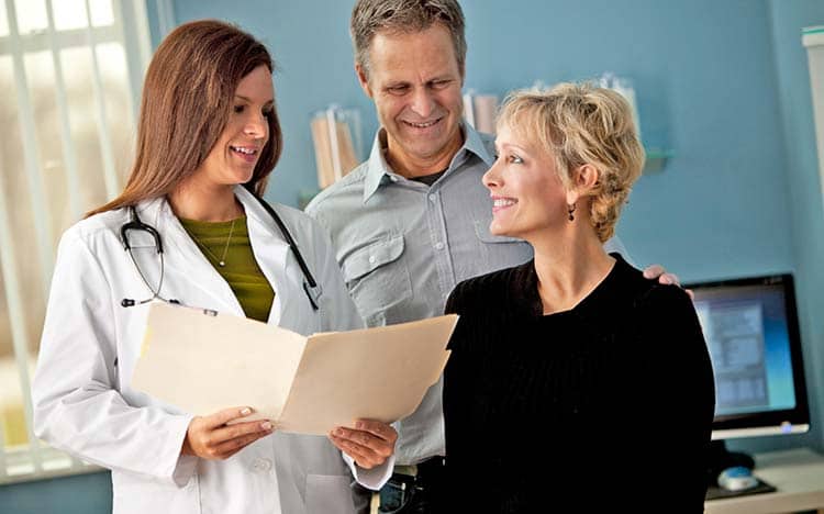 female doctor talking with couple