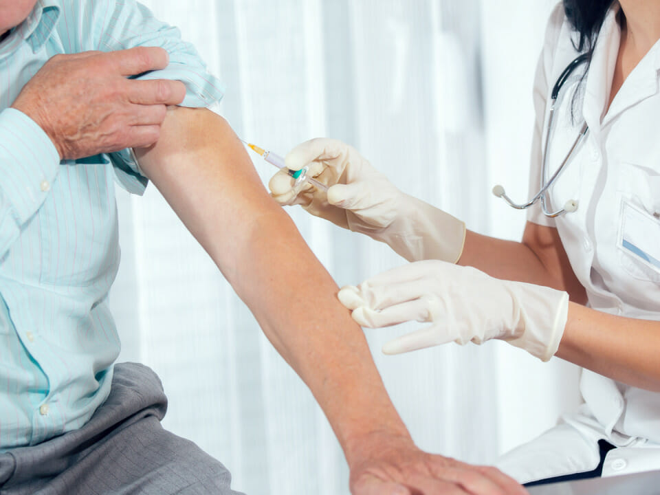 doctor injecting male patient