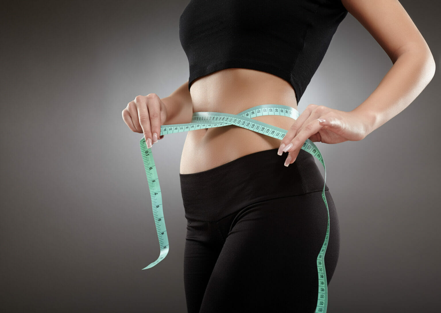 woman measuring her waist